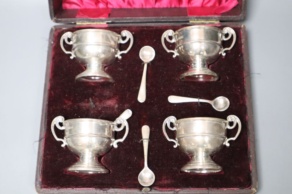 A cased set of four late Victorian silver salts, of two handled trophy cup form and matching spoons,